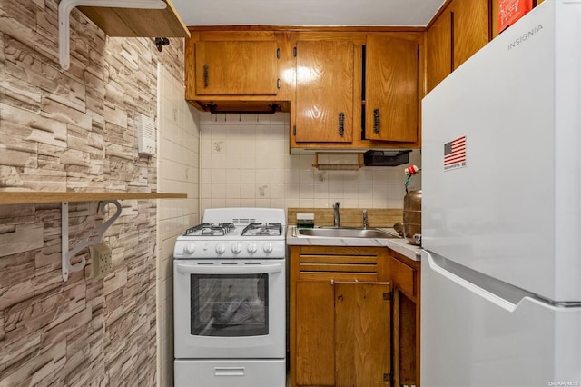 kitchen featuring backsplash, sink, and white appliances