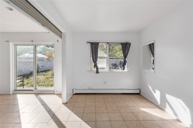 tiled spare room featuring a baseboard heating unit