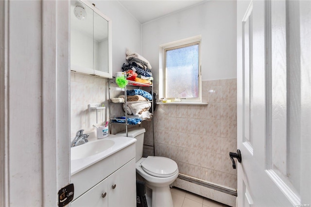 bathroom with baseboard heating, tile patterned floors, toilet, vanity, and tile walls