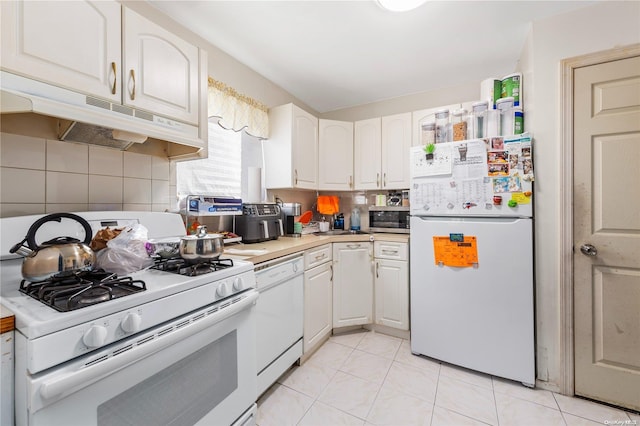 kitchen featuring white cabinetry, light tile patterned flooring, white appliances, and tasteful backsplash