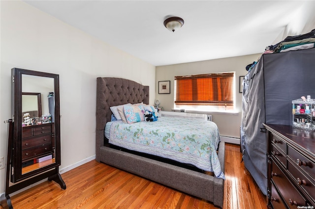 bedroom featuring light hardwood / wood-style floors and a baseboard radiator