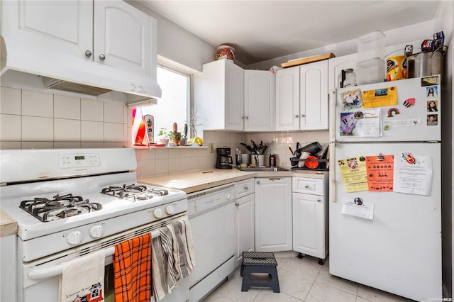 kitchen featuring tasteful backsplash, white cabinets, light tile patterned flooring, and white appliances