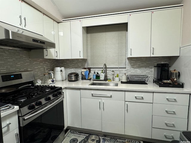 kitchen with exhaust hood, white cabinets, sink, gas range, and tasteful backsplash