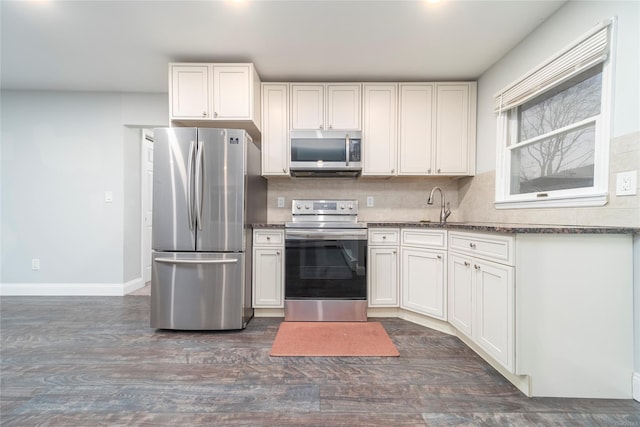 kitchen featuring tasteful backsplash, sink, white cabinetry, stainless steel appliances, and dark hardwood / wood-style flooring