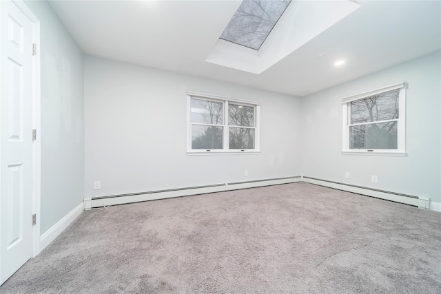 carpeted spare room with baseboard heating and a skylight