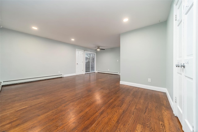 unfurnished room featuring baseboard heating, dark hardwood / wood-style floors, and ceiling fan