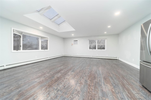 spare room with a skylight and dark hardwood / wood-style floors