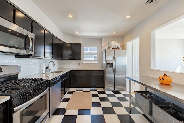 kitchen with decorative backsplash, appliances with stainless steel finishes, and sink