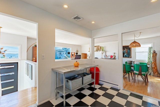 kitchen with wood-type flooring, a baseboard radiator, and hanging light fixtures