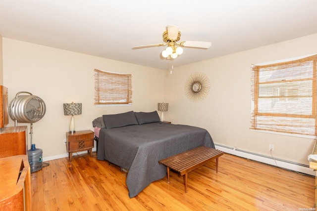 bedroom featuring baseboard heating, ceiling fan, and light hardwood / wood-style floors