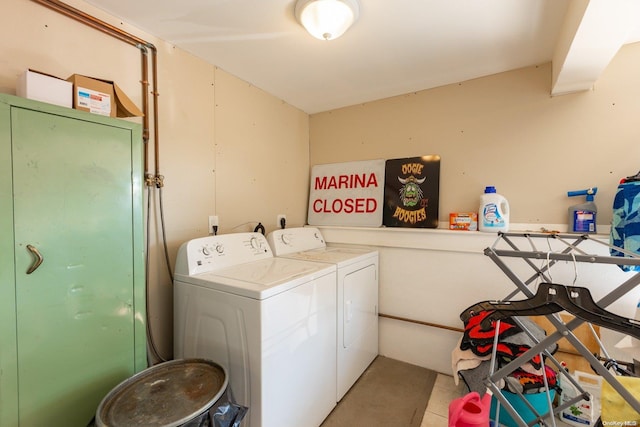 laundry area featuring light tile patterned floors and washing machine and dryer