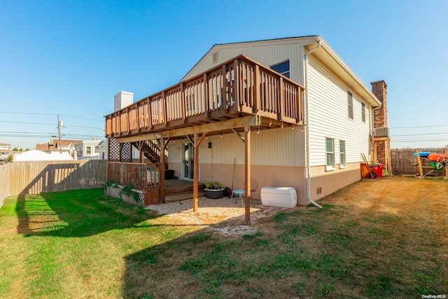 rear view of property featuring a lawn and a deck