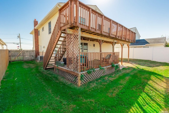 rear view of house with a lawn and a wooden deck