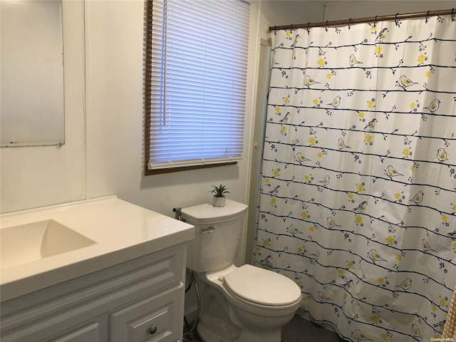 bathroom with a shower with shower curtain, vanity, and toilet