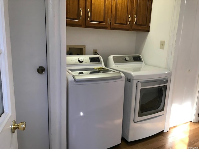 laundry room featuring separate washer and dryer, cabinets, and dark hardwood / wood-style floors