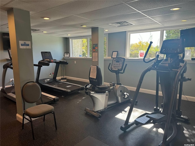 gym featuring a drop ceiling and a wealth of natural light