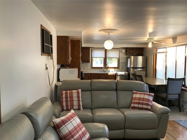 living room with ceiling fan, light hardwood / wood-style floors, and sink