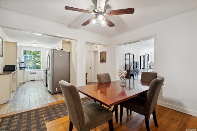 dining area with ceiling fan, crown molding, light wood-type flooring, and radiator heating unit