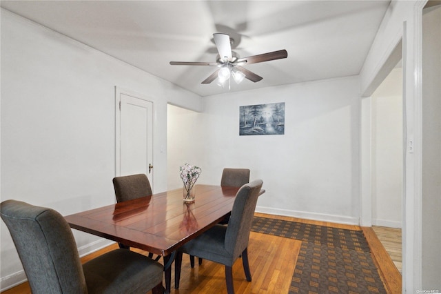 dining area with ceiling fan and wood-type flooring