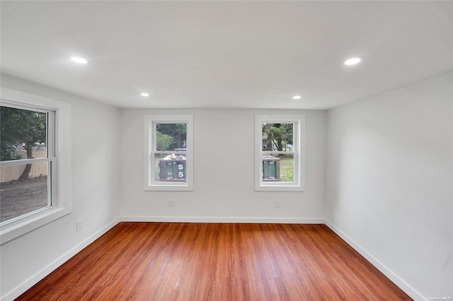 unfurnished room featuring a wealth of natural light and hardwood / wood-style floors