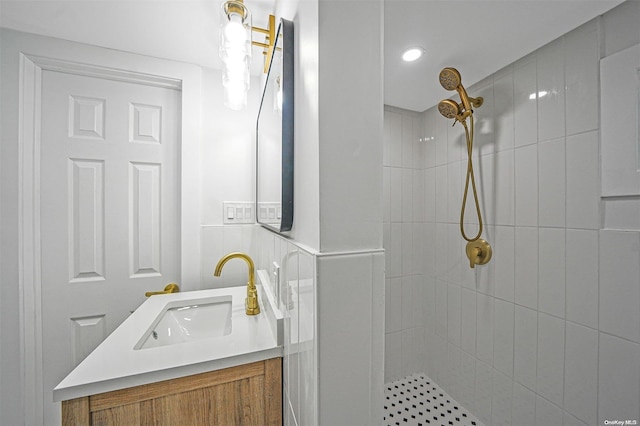 bathroom featuring a tile shower and vanity