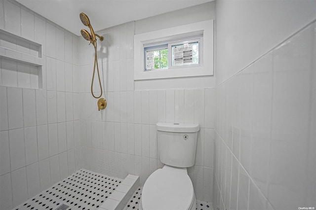 bathroom featuring a tile shower, tile walls, and toilet