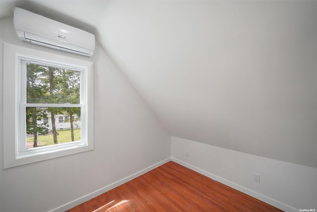 bonus room with vaulted ceiling, a wealth of natural light, hardwood / wood-style floors, and a wall mounted air conditioner