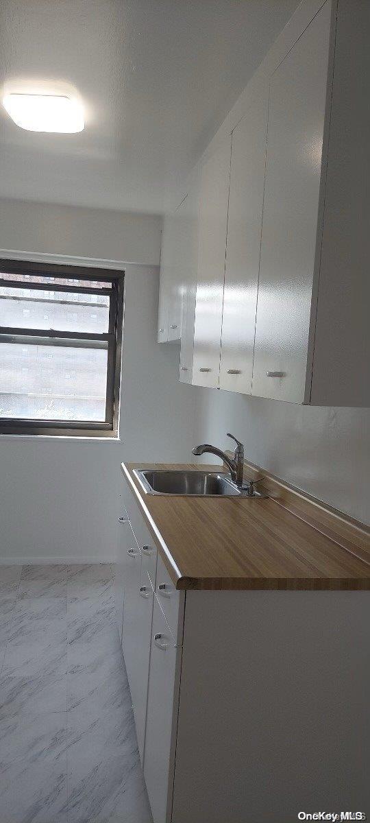 kitchen featuring white cabinetry and sink