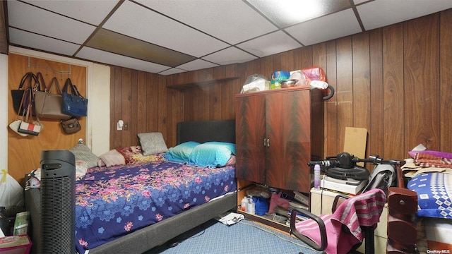 bedroom with wood walls and a drop ceiling