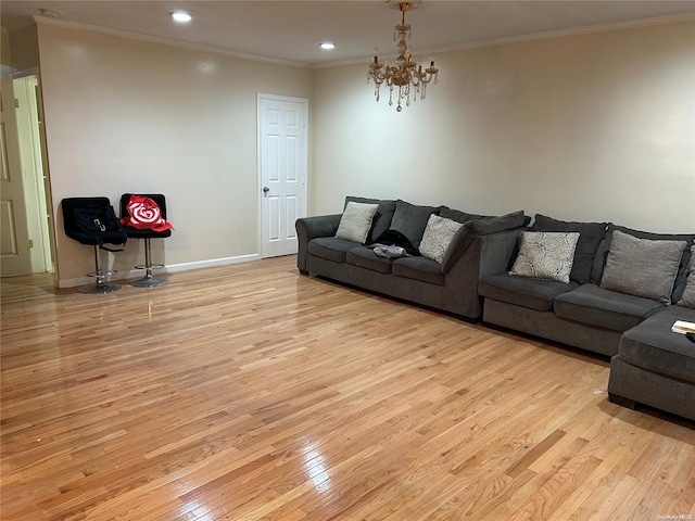 living room featuring crown molding, an inviting chandelier, and light wood-type flooring