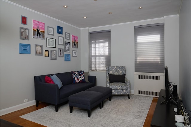 living room with light hardwood / wood-style flooring, radiator, and ornamental molding