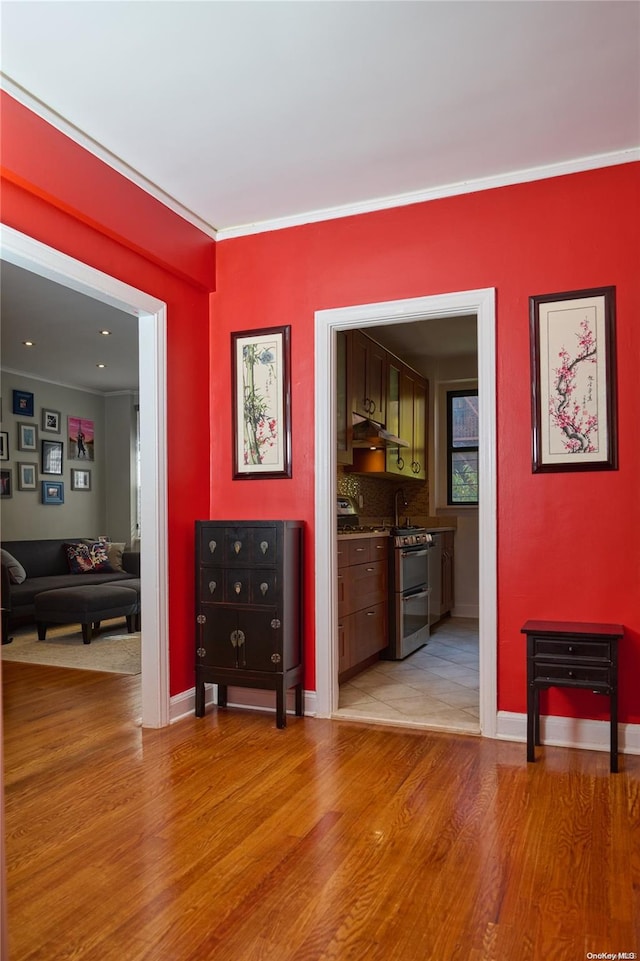 interior space featuring ornamental molding and light wood-type flooring