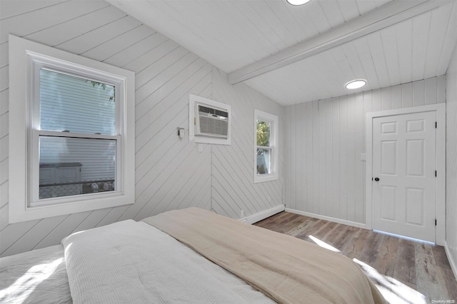 bedroom featuring hardwood / wood-style floors, vaulted ceiling with beams, wood walls, and an AC wall unit