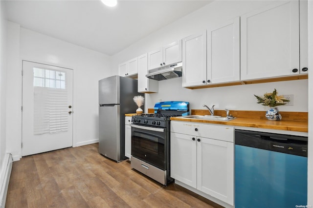 kitchen with sink, white cabinetry, appliances with stainless steel finishes, and wooden counters