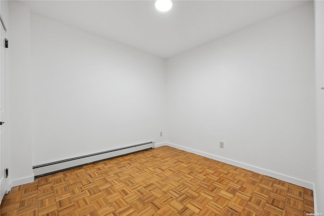 empty room with baseboard heating and light parquet flooring