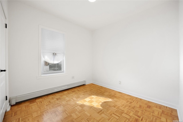 empty room featuring light parquet floors and a baseboard heating unit