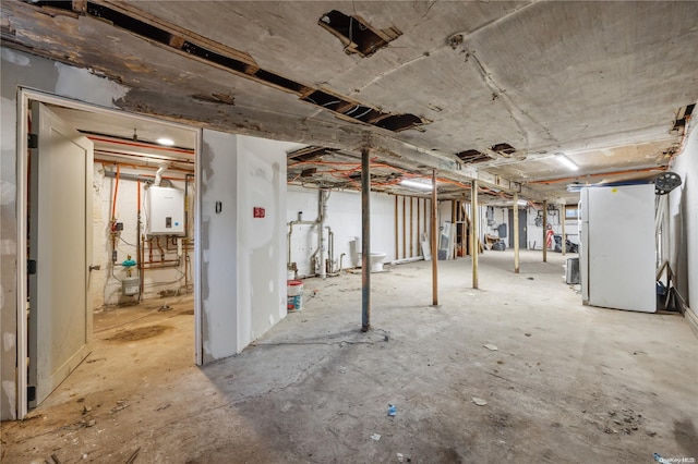 basement with water heater and white fridge