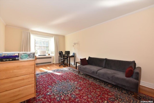 living room featuring radiator, wood-type flooring, and ornamental molding