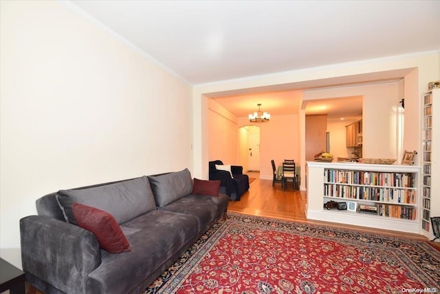 living room featuring crown molding, a chandelier, and hardwood / wood-style flooring