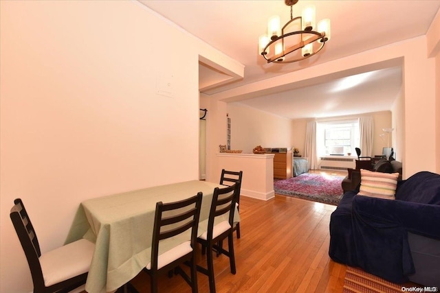 dining area featuring hardwood / wood-style flooring and a notable chandelier