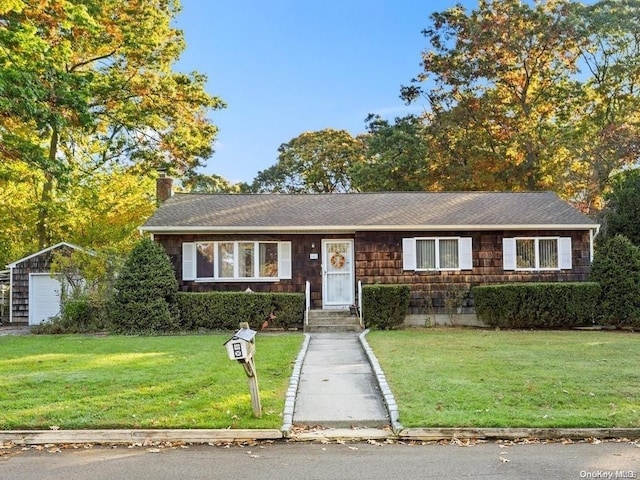 ranch-style home with a garage, an outdoor structure, and a front lawn