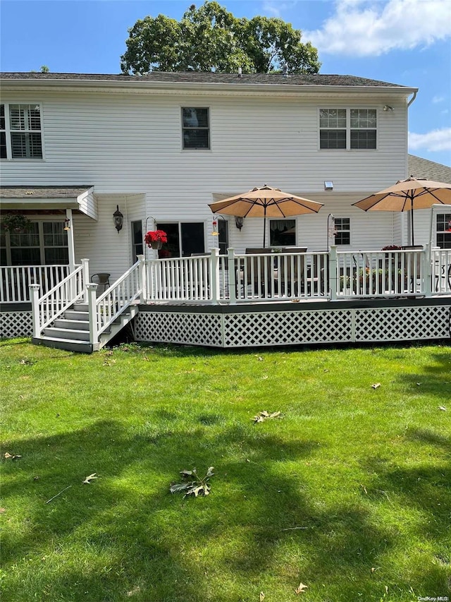 back of house with a deck and a yard