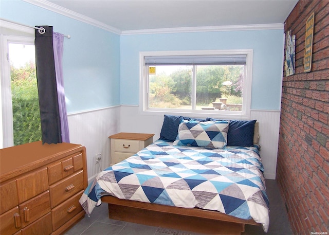 bedroom featuring tile patterned floors, brick wall, and ornamental molding