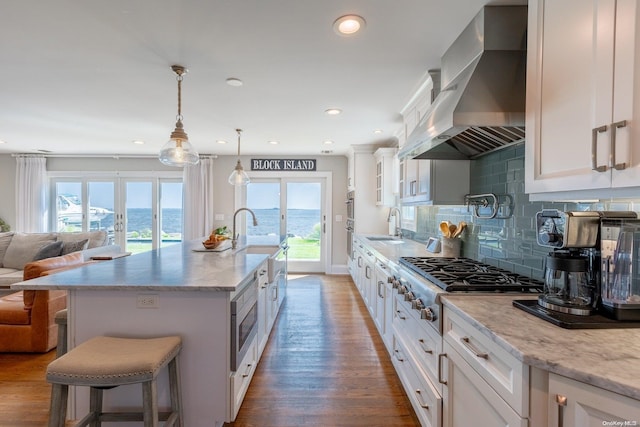 kitchen with dark hardwood / wood-style floors, white cabinetry, a wealth of natural light, and wall chimney exhaust hood