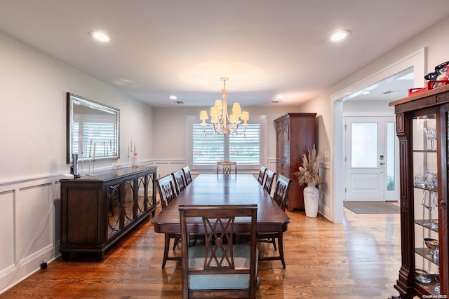 dining space featuring hardwood / wood-style flooring and a notable chandelier