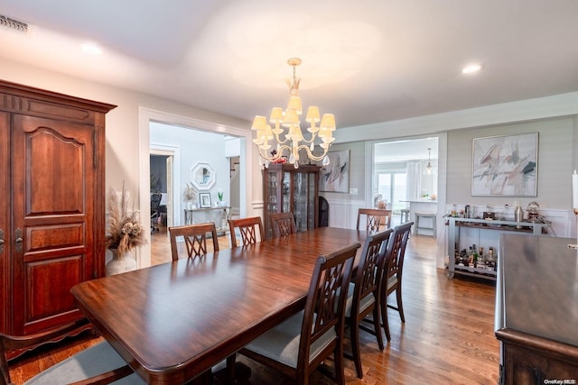 dining room with hardwood / wood-style flooring and an inviting chandelier