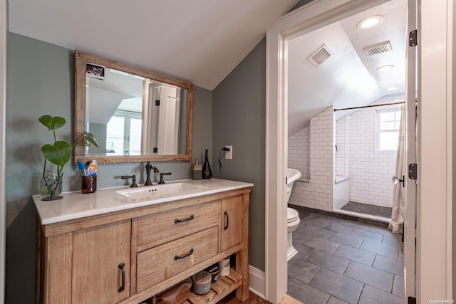 bathroom with vanity, tile patterned floors, vaulted ceiling, toilet, and tiled shower