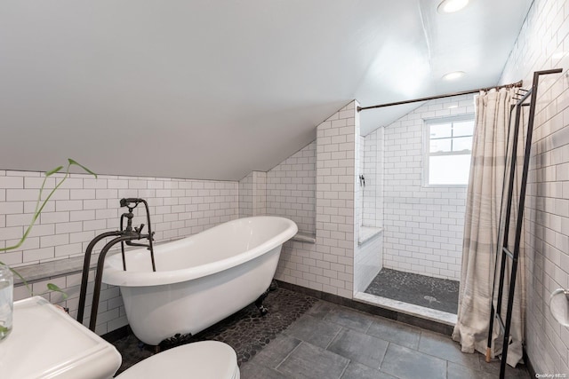 bathroom featuring tile walls, plus walk in shower, and lofted ceiling