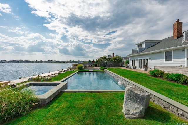 view of swimming pool with a lawn and a water view