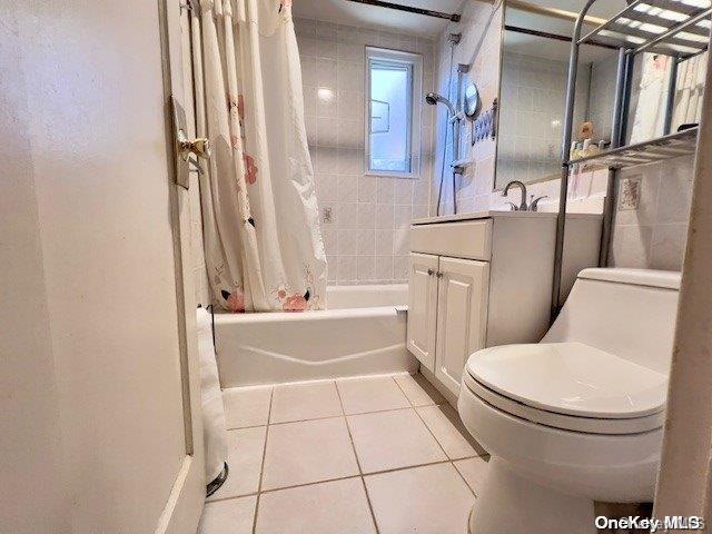 full bathroom with tile patterned flooring, vanity, toilet, and shower / tub combo with curtain